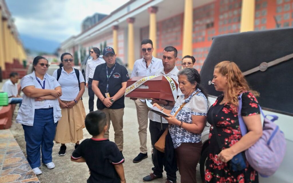 Equipo de la Unidad de Búsqueda con el féretro de Jhonn Charli y su familia