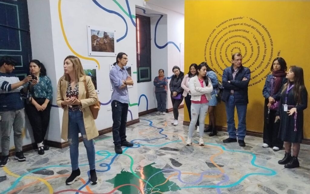 Personas viendo imágenes de la exposición El camino de la búsqueda en museo de Pasto