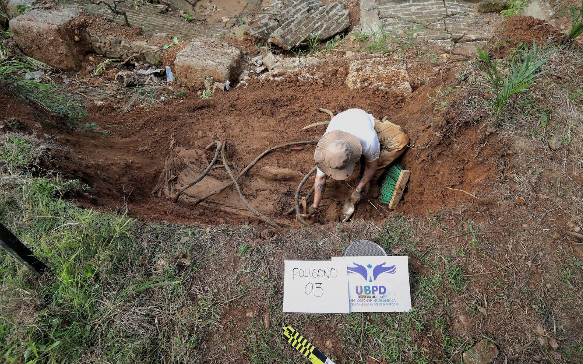 Funcionario de la Unidad de Búsqueda en plena recuperación de un cuerpo en el cementerio de Zaragoza, Antioquia.