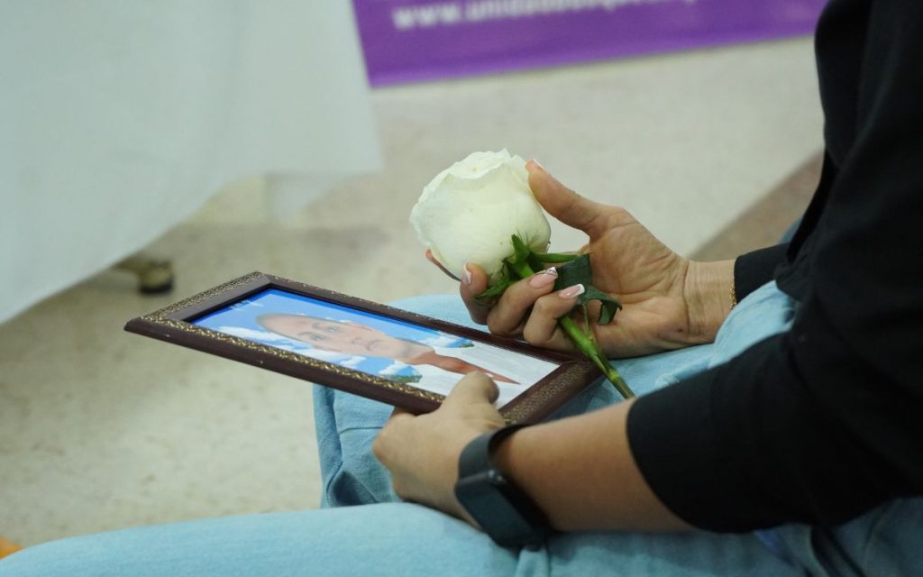 La escena ocurre en una sala discreta de la ciudad de Arauca durante la entrega digna del cuerpo de Brenda, una venezolana desaparecida desde 2012. Su hija, Breliacni Yailin Lara, estuvo presente junto con algunos de sus familiares que viajaron desde Guasdualito, en el estado venezolano de Apure. Desde el momento en que entraron al salón, ella se aferró a la fotografía como única forma de hacer presencia en ese reencuentro demorado por trece años.