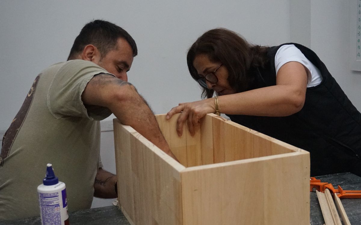 En un pequeño taller de carpintería en algún rincón de Manizales, el sonido de las sierras, los martillos y la lija no era el de una simple fabricación. Era el eco de un pasado violento buscando redención. Allí un grupo de hombres, muchos sin experiencia previa en carpintería, se reunían cada semana para dar forma a algo más que madera: construían memoria, tejían dignidad y reconciliación.