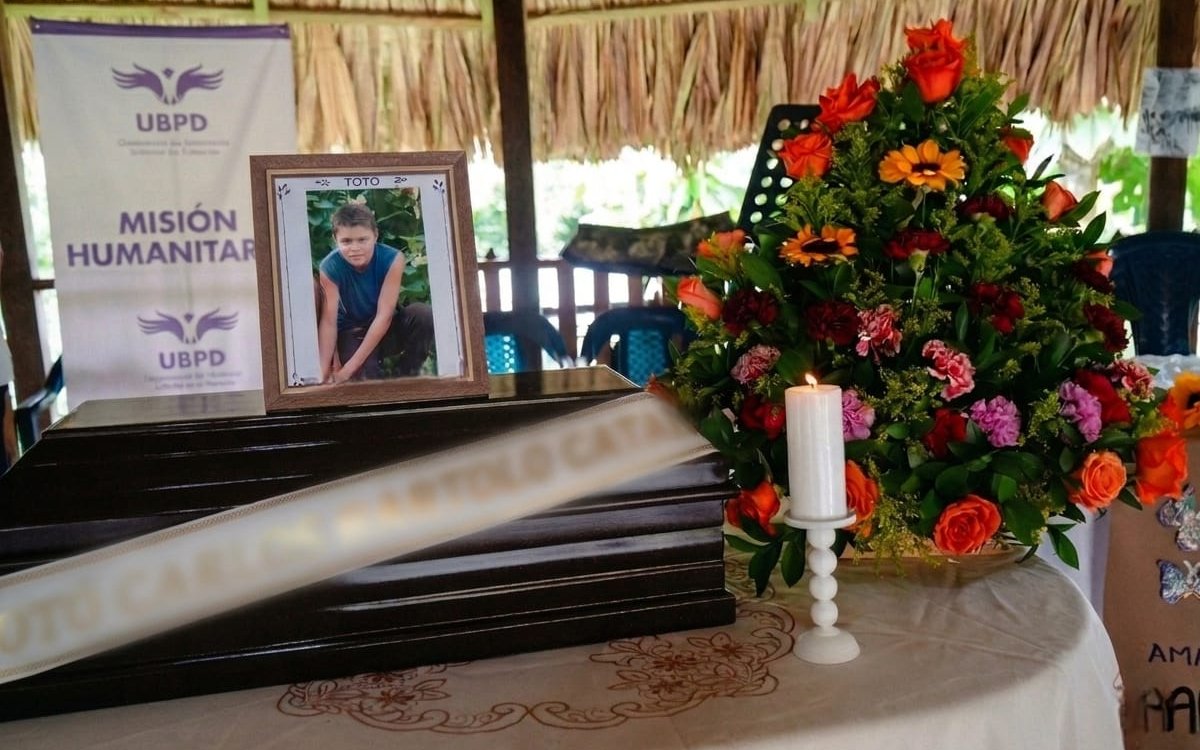 Detalle del altar con el cofre ceremonial de madera oscura cruzado por una cinta con el nombre 