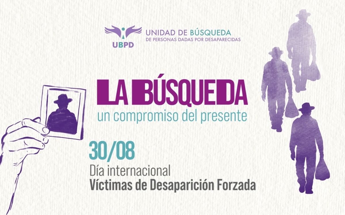 Afiche conmemorativo con fondo claro sobre el que se lee: Unidad de Búsqueda de Personas Dadas por Desaparecidas, UBPD. En el centro, en letras moradas y verdes, el título 'La búsqueda, un compromiso del presente'. Abajo dice: '30/08 Día Internacional de las Víctimas de Desaparición Forzada'. A la izquierda, una mano sostiene la fotografía tipo retrato de la silueta de un hombre con sombrero. A la derecha, tres siluetas en tonos morados representan personas alejándose con sombreros y bolsas.