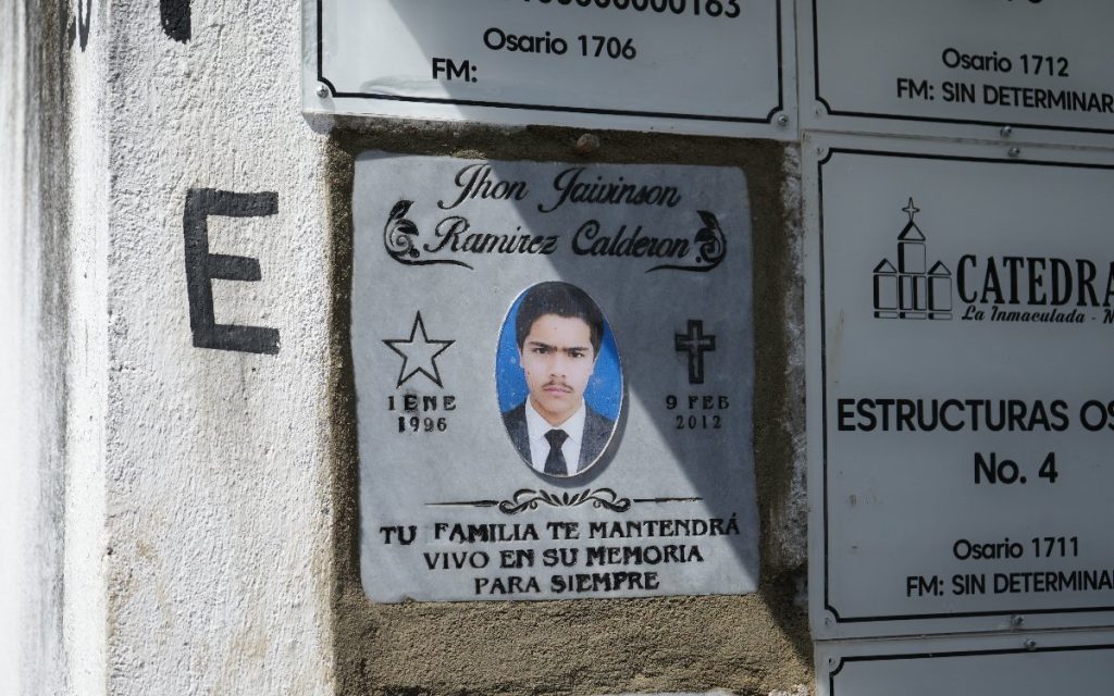 Lápida de mármol sellando el osario con la fotografía de Jhon Jaivinson Ramírez Calderón. Muestra las fechas primero de enero de 1996 y nueve de febrero de 2012, junto a la inscripción: Tu familia te mantendrá vivo en su memoria para siempre.