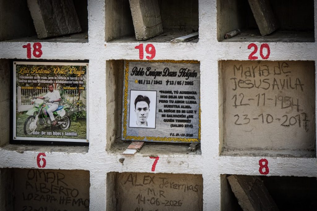 Detalle de una pared de osarios con nichos numerados en rojo. El nicho número 19 tiene una placa conmemorativa con el nombre «Pablo Enrique Daza Holguín», las fechas «01/11/1943 - 13/05/2005», la foto del fallecido y la cita bíblica del Salmo 27:1.